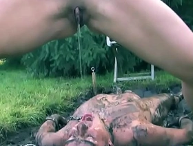 Mistress pissing on sub outdoors in the mud